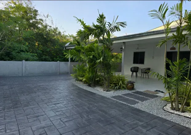 Patterned decorative concrete driveway beside landscaped planting